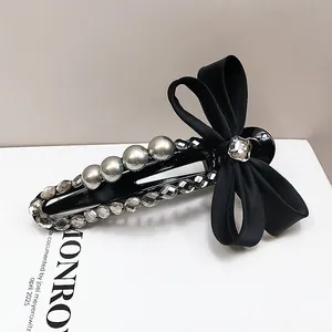 Elegant black ribbon bow hair clip with grey pearls and rhinestones on white base