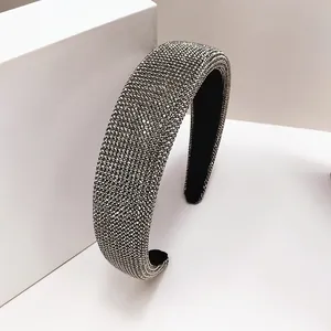 Detail van een zilveren spons hoofdband met fonkelende strassteentjes op witte standaard
