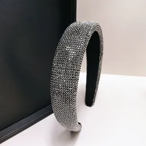 Detail van fonkelende zilveren steentjes en zwarte fluwelen voering op de haarband