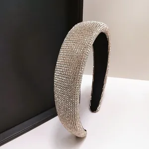 Detailopname van de gevoerde champagne gouden hoofdband met sprankelende kristallen