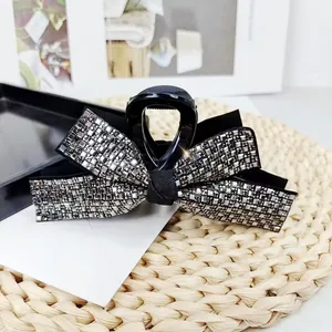 Large black bow hair claw clip with shimmering silver rhinestones and fabric center knot