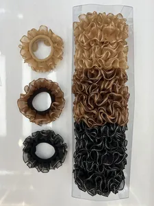 Detalle de coleteros de organza con bordes ondulados en champán, marrón y negro en caja
