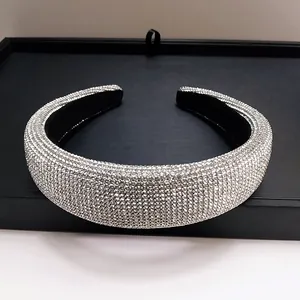 Detailopname van dikke zilveren strass haarband met zwarte fluwelen binnenkant