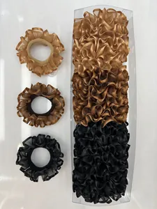 Detalle de coleteros rizados en color dorado, marrón y negro dentro de una caja transparente
