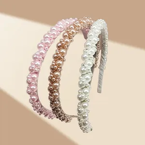 Three elegant pearl headbands in white, pink and champagne gold on a geometric background