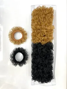 Detalle de coleteros de organza con volantes en negro y marrón dorado en caja premium