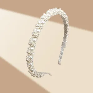 Detailed macro view of an elegant headband with densely set white pearls and a golden frame