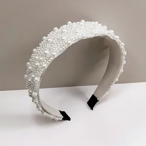 Vista macro de diadema ancha con perlas cosidas a mano y forro interior de terciopelo suave