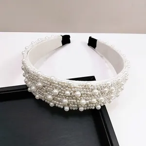 Detalle de diadema de perlas blancas de lujo con cuentas cosidas a mano y puntas negras