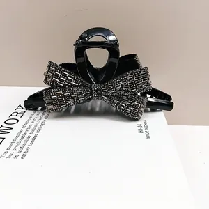 Sparkling black bow hair claw clip with silver rhinestones on a fashion catalog page