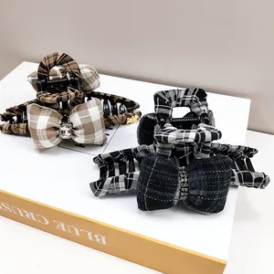 Detail of plaid bow hair claws with sparkling rhinestones and elegant fabric texture