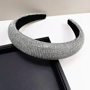 Detail of silver rhinestone padded headband on black textured tray showing clear sparkle