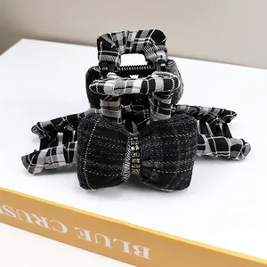Detail view of black and white checkered bow hair claw clip with sparkling rhinestones