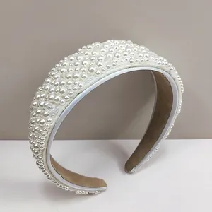 Detalle de la diadema ancha con perlas blancas cosidas a mano y forro interior marrón