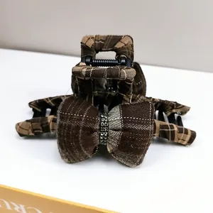 Close-up of vintage brown plaid bow hair claw clip with sparkling rhinestone details