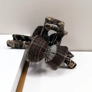 Detail of checkered fabric hair claw clip with bowknot and sparkling rhinestone center