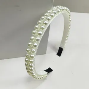 Primer plano de la diadema acolchada blanca con dos filas de perlas de marfil cosidas a mano
