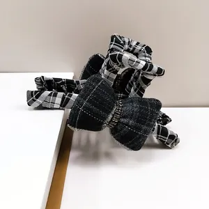 Elegant tweed bow hair claw clip with rhinestones and classic black white plaid pattern