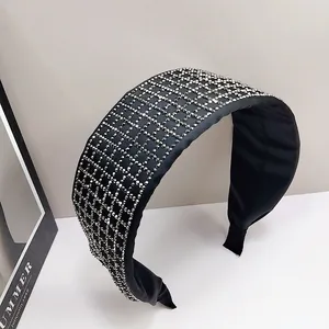 Detail of black wide headband with sparkling silver rhinestones in a grid pattern