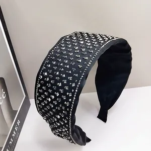 Detail of black fabric headband with sparkling silver square rhinestones and padded ends