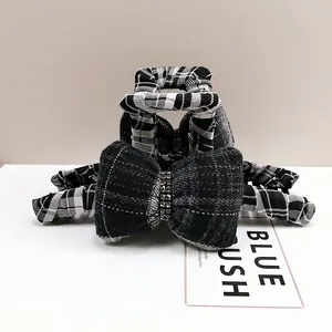 Detailed view of British style checkered bow hair claw with sparkling rhinestones