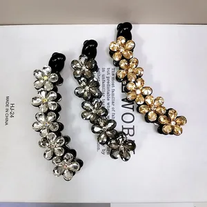 Vista dettagliata di tre fermagli a banana con fiori di cristallo in argento, grigio e oro