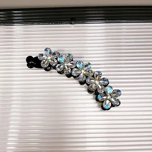 Dettaglio del fermaglio a banana con fiori di prugna in cristallo e strass cangianti