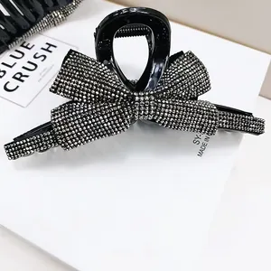 Dettaglio di un fermaglio per capelli con fiocco di strass scintillante su base nera