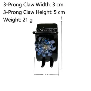 Elegant 3-tooth hair claw clip featuring a blue crystal flower and polished black finish