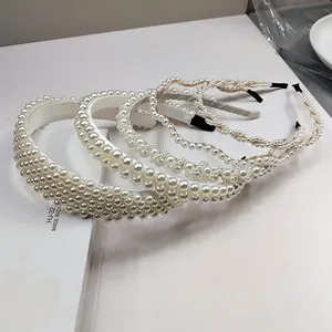 Vista de detalle de cinco diademas de perlas blancas con diseños de cuentas tejidas a mano