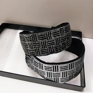 Macro detail of high-end wide headband with sparkling crystal lattice on black fabric