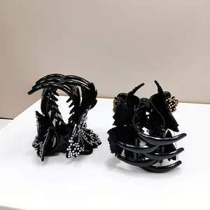 Elegant rhinestone flower hair claw clip with black fabric bow for luxury hair styling