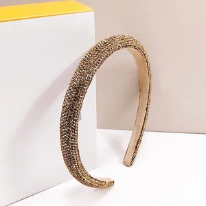 Detailed view of champagne gold crystal headband resting on an elegant gift box
