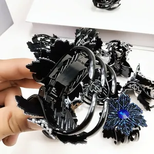 Detail of floral rhinestone hair claw clip with black finish and sparkling blue crystals