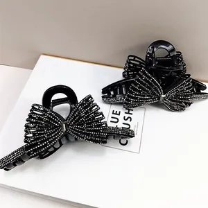 Dettaglio macro di due mollette nere a fiocco con strass brillanti incastonati