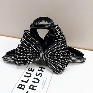 Elegante molletta per capelli a fiocco nero con strass d'argento e cristallo centrale