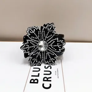 Macro shot of elegant black flower hair claw with sparkling silver rhinestones