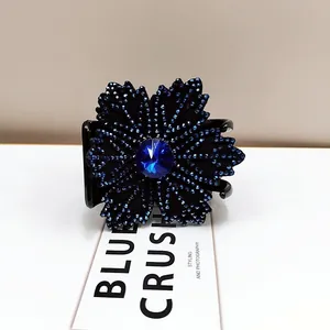 Detailed close-up of blue crystal flower hair claw with rhinestones on a clean background