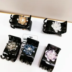 Detailed view of five crystal flower hair claws in amber, white, grey, blue and purple