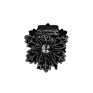 Detailed close-up of a floral hair claw with sparkling rhinestones and a central crystal