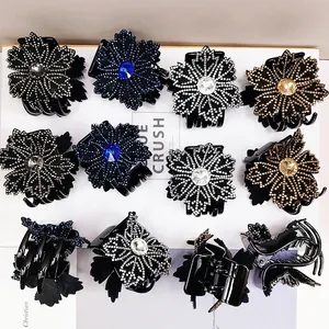 Detailed view of floral hair claws with rhinestones and central crystal in four colors