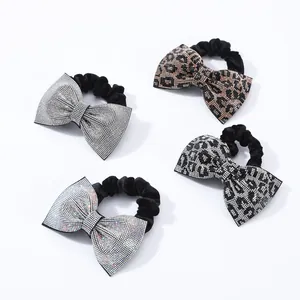 Dettaglio di quattro elastici per capelli con fiocchi di strass e motivi leopardati