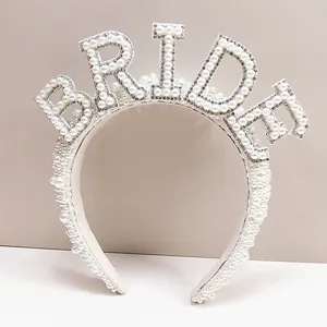 Detailed view of pearl bridal headband featuring BRIDE rhinestone lettering design