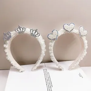 Detail of handmade pearl headbands with silver rhinestone crowns and heart motifs