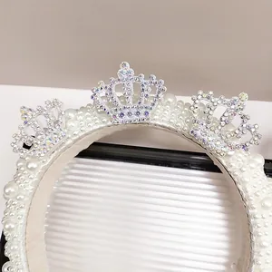 Detailed view of handmade bridal headband with white pearls and colorful rhinestone crowns