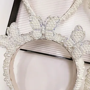 Close-up detail of luxury pearl headband with three handcrafted crystal butterfly accents