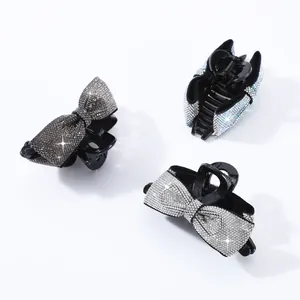 Details von drei glitzernden Strass-Bogenhaarkrallen in Schwarz, Silber und Irisierend
