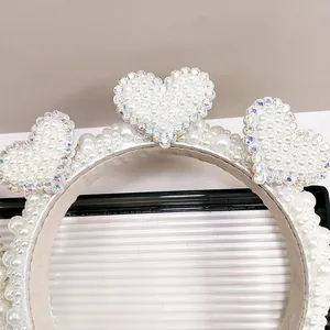 Close-up of pearl headband with rhinestone heart details for wedding and party wear