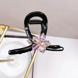 Pince à cheveux noire brillante avec fleurs en cristal violet et détails dorés