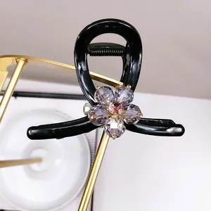 Pince à cheveux noire élégante ornée d'une fleur en cristal violet et strass brillants